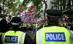 Des policiers face à des partisans de Tommy Robinson, militant d'extrême droite britannique, rassemblés pour une marche organisée par Unite The Kingdom, le 16 mai 2026 à Londres