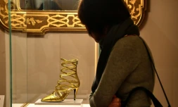 Une visiteuse de l'exposition "Aux pieds des dieux" admire une chaussure au Palais Pitti de Florence, le 30 janvier 2020 en Italie