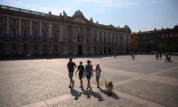 Une famille traverse la place du Capitole Ă Toulouse, le 28 juillet 2024