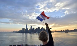 Une passagère du paquebot Queen Mary 2 agite des drapeaux français à son arrivée à New York, le 1er juillet 2017