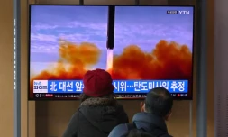 Des passants regardent un écran de télévision montrant un lancement de missile par la Corée du Nord, le 5 mars 2022 à Séoul