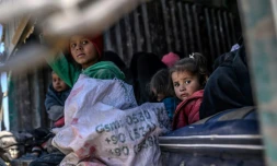 Des enfants et des femmes à bord d'un camion fuient la dernière poche du groupe Etat islamique (EI) à Baghouz, dans l'est de la Syrie, le 20 février 2019
