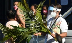 Des fidèles philippins se dirigent vers l'église pour le dimanche des Rameaux, le 5 avril 2020,à Manille