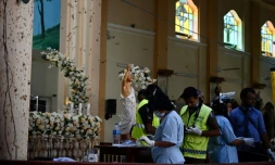 Du personnel de sécurité relÚvent des traces dans l'église Saint-Sebastien de Negombo, le 22 avril 2019 au lendemain des explosions meurtriÚres