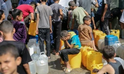 Des enfants palestiniens affluent à une distribution d'eau à Nousseirat,  dans le centre de la bande de Gaza, le 4 septembre 2025 