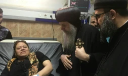 Un prêtre copte parle à une femme dans un hôpital de Beni Mazar, au sud du Caire, le 2 novembre 2018 après une fusillade sur un bus transportant des coptes dans la région de Minya