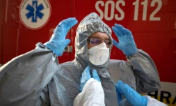 Un membre du personnel soignant revêt sa tenue de protection avant de s'occuper de malades, à Bratislava, en Slovaquie, le 16 mars 2020