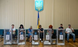 Des observateurs installés prÚs des urnes dans un bureau de vote, lors des législatives, le 21 juillet 2019 à Kiev, en Urkaine