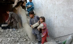 Des enfants aident leurs parents à la reconstruction de leur maison détruite par un tremblement de terre, le 29 octobre 2015 dans la province de Nangarhar, dans l'est de l'Afghanistan