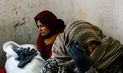 Une femme (g), avec son bébé dans les bras, attend le 19 janvier 2016 dans la gare de Presevo, en Serbie, un train pour gagner la Croatie