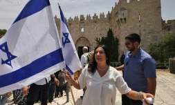 La ministre israélienne des Transports Miri Regev agite le drapeau israélien avant la "marche des drapeaux", devant la Porte de Damas à Jérusalem-Est le 18 mai 2023
