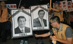 Un militant pour l'indépendance de Taïwan s'apprête à brûler des photos des dirigeants chinois et taïwanais, le 7 novembre 2015 à Taipei