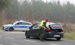 Un policier polonais procède au contrôle d'un véhicule à l'entrée d'une zone militaire située à 3 km de la frontière avec le Bélarus, le 14 novembre 2021 