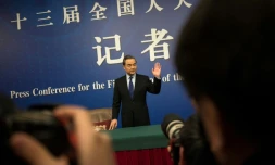 Le ministre chinois des Affaires étrangères, Wang Yi, salue les photographes à son arrivée pour une conférence de presse le 8 mars 2018, à Pékin.