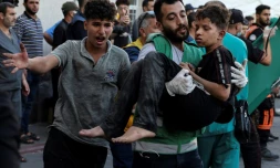 Un homme porte un enfant blessé à l'hÎpital al-Chifa aprÚs des frappes israéliennes dans la ville de Gaza, le 10 octobre 2023