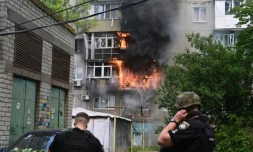 Des policiers face à un bâtiment en flammes après une frappe aérienne dans le centre de Kramatorsk, en Ukraine, le 19 juillet 2022