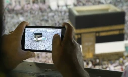 Un homme prend une photo de la Kaaba, au centre de la Grande mosquée de La Mecque le 15 août 2018 à l'occasion du grand pèlerinage