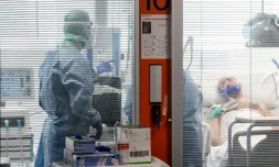 Des membres du personnel médical en combinaison de protection prodiguent des soins à un patient atteint par le nouveau coronavirus dans une unité spéciale de l'hôpital de Brescia, le 17 mars 2020 en Italie