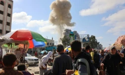 Des Palestiniens regardent la fumée d'un bombardement israélien sur le marché de Firas, à Gaza, le 11 avril 2024