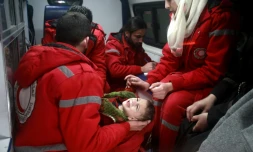 Du personnel du Croissant Rouge syrien évacue un enfant de Douma, dans la Ghouta orientale assiégée par le régime de Damas, le 26 décembre 2017  