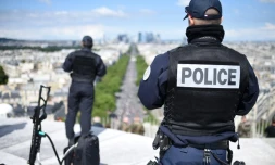 Des policiers suveillent le défilé militaire depuis le sommet de l'Arc de Triomphe, le 14 juillet 2016 à Paris