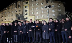Le ministre turc de l'Intérieur, Ali Yerlikaya (C), s'adresse aux médias devant l'hôtel sinistré Grand Kartal, mercredi soir, dans la station de ski de Kartalkaya (centre de la Turquie)