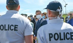 Le ministre de l'Intérieur français Gérald Darmanin (c) discute avec des policiers à Calais (Pas-de-Calais), le 12 juillet 2020