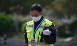 Un policier se fige lors des 3 minutes de silence en mémoire des morts du Covid-19, le 4 avril 2020 à Wuhan 