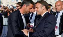 Le patron du comité d'organisation de Paris 2024 Tony Estanguet (G) serre la main du président Emmanuel Macron à l'arrivée de la flamme olympique à Marseille le 8 mai 2024