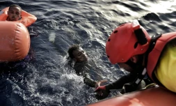 Un sauveteur de l'ONG Proactiva Open Arms aide un migrant à sortir de l'eau, le 3 octobre 2016 au large des côtes libyennes