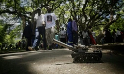 Un char miniature et des personnes dans un parc en face devant le Parlement Zimbabwéen, le 21 novembre 2017 