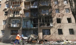 Une habitante passe devant un immeuble touché par des frappes ukrainiennes à Koursk, le 16 août 2024 en Russie