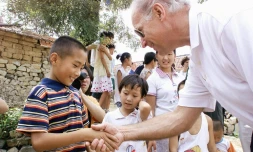 Joe Biden, alors chef de la commission des affaires étrangères du Sénat salue un enfant du village de  Yanzikou, le 10 août 2001
