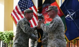 Le général Austin Scott Miller (G), chef des forces américaines en Afghanistan, remet le drapeau de la mission de l'Otan dans le pays au général Kenneth McKenzie, chef du Commandement central américain (Centcom) lors d'une cérémonie à Kaboul, le 12 juillet 2021
