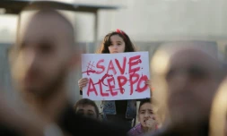 Une jeune Syrienne tient une pancarte "Sauvez Alep", lors d'un rassemblement de solidarité dans la ville libanaise de Tripoli, le 1er mai 2016