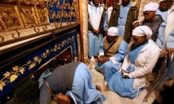 Des pèlerins nigérians prient la veille de Noël sur le lieu de naissance présumé de Jésus, dans la basilique de la Nativité à Bethléem en Cisjordanie, le 24 décembre 2018