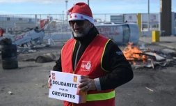 Un militant CGT porte une cagnotte pour les grévistes, lors d'un repas de noël organisé le 24 décembre 2019 au port de Marseille