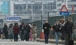 Des passagers évacuent l'aéroport de Bruxelles, le 22 mars 2016 après deux explosions