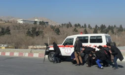 Des journalistes afghans se refugiant derriĂšre une ambulance Ă Kaboul le 21 janvier 2018