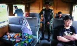 Un soldat au milieu des passagers du train de 12H33, le 21 novembre 2016 à Narathiwat dans l'extrême sud de la Thaïlande