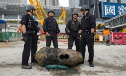 Des démineurs posent devant une bombe de la Seconde Guerre mondiale découverte sur un chantier de construction à Hong Kong, le 11 mai 2018