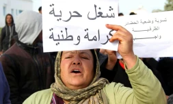 Une Tunisienne brandit une pancarte "Travail, liberté, dignité, nationalisme", pendant une manifestation à Kasserine, le 21 janvier 2016