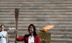 L'ex-championne japonaise de natation Imoto Naoko brandit la flamme olympique qu'elle vient de recevoir des autorités grecques à Athènes, le 19 mars 2020 