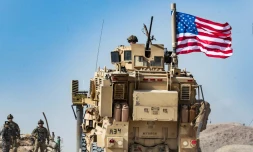 Un véhicule militaire américain lors d'une manifestation de Kurdes prÚs de Ras al-Aïn aux abords de la frontiÚre turque, le 6 octobre 2019