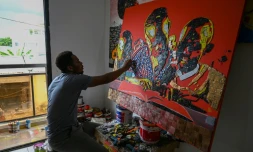 L'artiste vorien Mounou Désiré Koffi réalise une toile avec des claviers de téléphone usagés dans sa résidence de Bingerville, une commune d'Abidjan, le 28 avril 2022