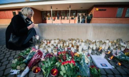 Des fleurs et des bougies déposées devant une école où un homme armé d'un sabre a tué deux personnes, le 23 octobre 2015 à Trollhättan, en Suède