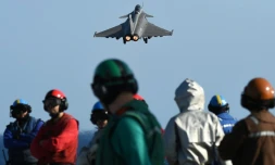Des militaires français sur le pont du Charles de Gaulle regardent un rafale partir pour bombarder au-dessus des zones contrôlées par le groupe Etat islamique (EI) en Irak et Syrie le 23 novembre 2015