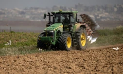 Un agriculteur en tracteur dans un champ agricole près de la frontière entre le sud d'Israël et la bande de Gaza, le 21 mai 2025