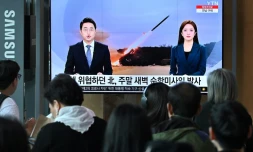 Des personnes regardent un écran dans une gare de Séoul diffusant des images d'un essai de missile nord-coréen, le 22 juillet 2023