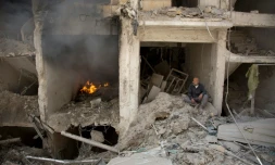 Un homme au milieu des décombres d'un immeuble détruit le 8 juin 2016 à Alep